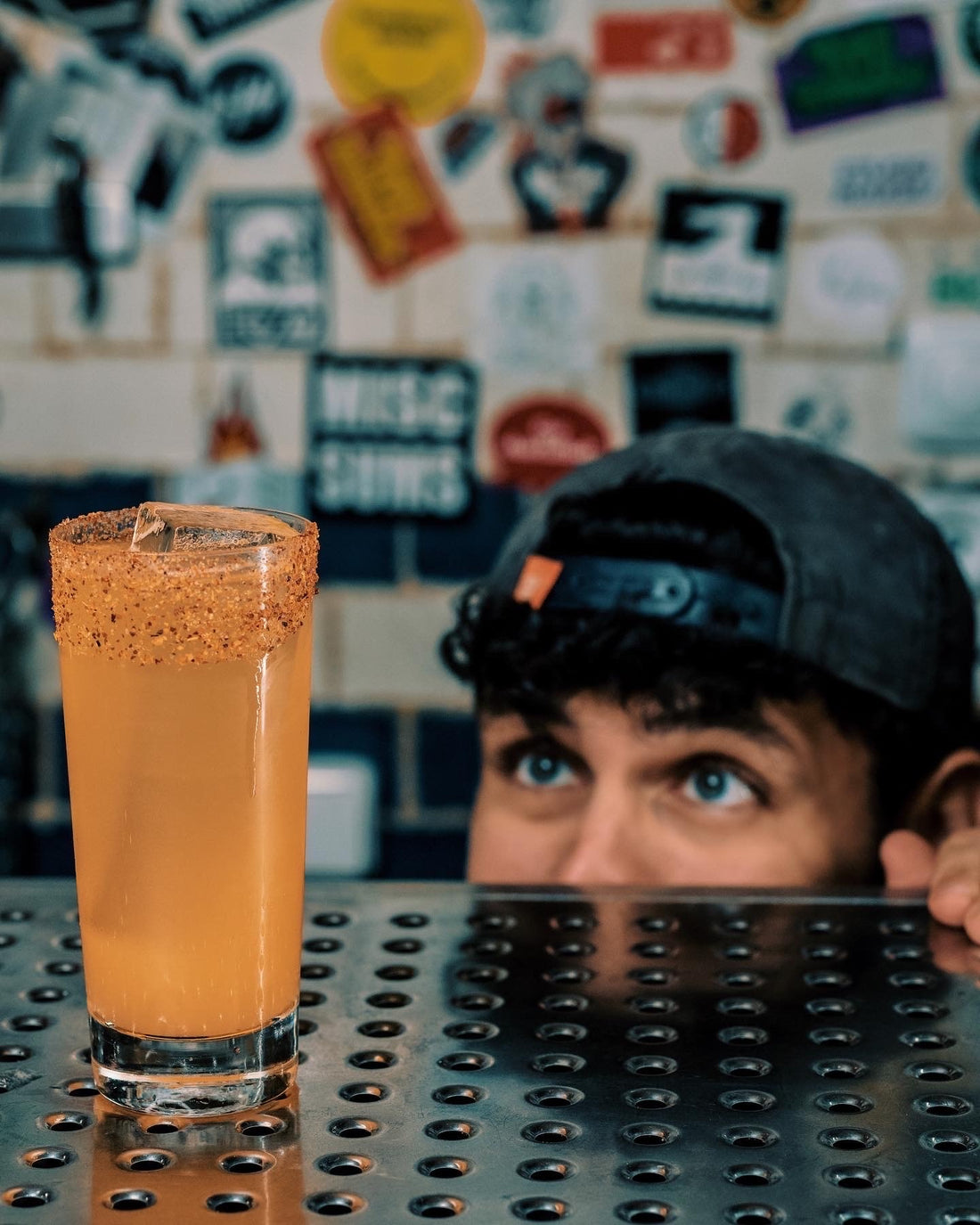 A guy peering over a counter at a Michelada